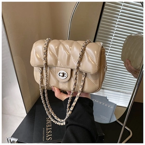 Close-up of beige quilted crossbody bag featuring a silver chain strap and twist lock