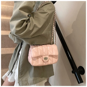 Lifestyle shot of light pink quilted chain crossbody bag featuring metal turn-lock closure
