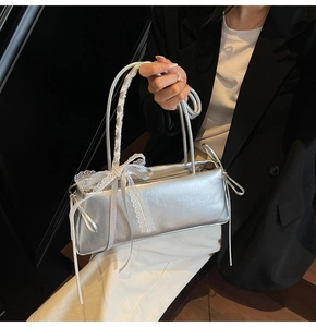 Silver pleated pillow bag with delicate white lace trim and bow knot detail on strap