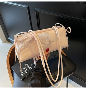 Close-up of a pink pleated pillow bag with a delicate white lace bow and thin strap