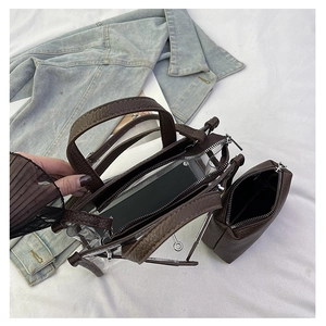 Detailed top view of transparent Kelly bag with brown leather pouch and denim jacket