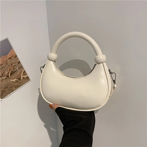 Minimalist beige crescent hobo handbag with circular handle and silver buckle detail