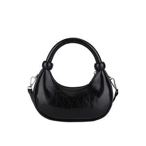 Glossy black pleated hobo bag with top handle and detachable shoulder strap on white backdrop