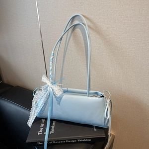 Close-up of light blue pleated pillow bag with delicate white lace bow and ribbon detail