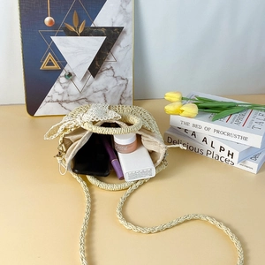 Top view of beige straw bucket bag interior with lace bow showing storage capacity