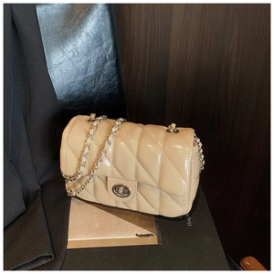 Detail of beige patent leather quilted bag with chain strap and metallic swivel lock