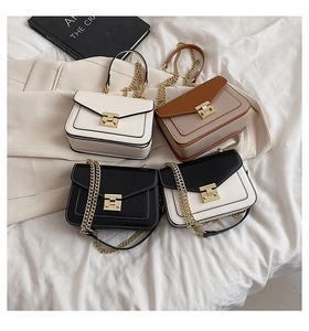 Dettaglio di piccole borse a catena in bianco, nero, marrone e ecopelle bicolore elegante