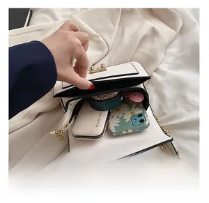 Vista dall'alto dell'interno della borsa a tracolla bianca con spazio per cellulare e trucchi