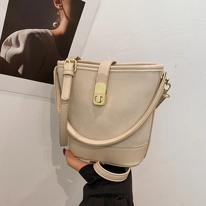 2025 stylish beige bucket handbag with suede trim and gold clasp crossbody strap