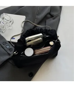 Detail view of black nylon cloud bag interior showing spacious storage and silver chain strap