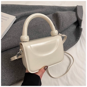 Vue de dessus d'un mini sac carré en cuir PU blanc crème avec poignée ronde épaisse
