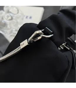 Close-up of polished silver hardware hook and durable black nylon fabric on the bag