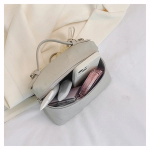 Détail de l'intérieur du sac à main minimaliste montrant l'espace pour téléphone et maquillage