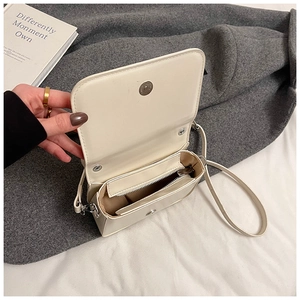 Détail de l'intérieur du sac crème avec compartiment zippé et rabat magnétique