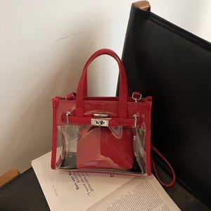 Fashionable red transparent PVC jelly handbag with leather trim and inner pouch on chair