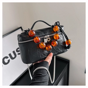 Détail du sac plissé vintage avec poignée en perles ambrées et bandoulière argentée