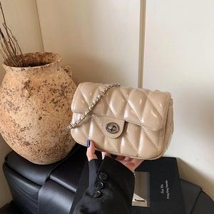 Quilted beige flap crossbody bag with silver chain strap and metallic twist lock clasp