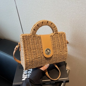 Handmade straw handbag with leather strap and metal clasp for beach and casual wear