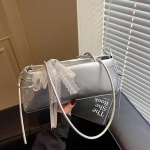 Silver pleated pillow bag with metallic finish and bow detail on a leather background