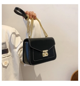 Dettaglio borsa nera a tracolla con cuciture bianche a contrasto e catena oro