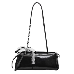 Minimalist black rectangle shoulder bag featuring a white lace bow on the glossy strap
