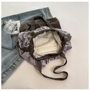 Détail intérieur du sac seau en toile grise avec poche zippée et fermeture magnétique