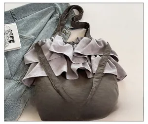 Détail du sac cabas en toile à volants superposés avec larges bandoulières en gris foncé