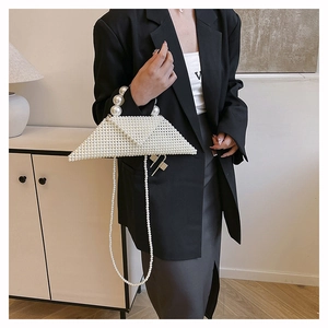 Détail d'un sac à main triangulaire en perles blanches tressées avec bandoulière