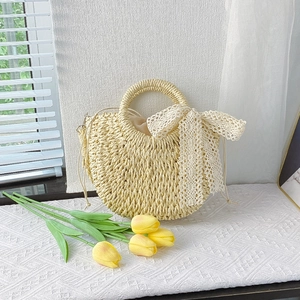 Beige woven half-moon bag with lace bow and straw handle for summer vacation