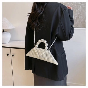 Détail du sac à main triangulaire en perles montrant la texture tissée et la bandoulière