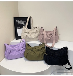 Group display of casual minimalist nylon crossbody bags with bow details in five colors