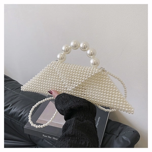 Détail d'un sac à main triangulaire en perles blanches tressées avec longue bandoulière