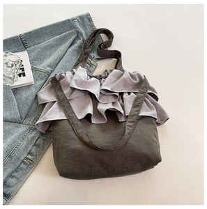 Détail du sac cabas en toile grise avec bordure volantée lavande et texture plissée