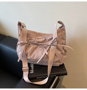 Detail of pink nylon tote bag with dual bow drawstring and adjustable wide strap