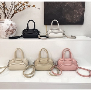 Selection of five mini leather Boston bags in various colors on display steps