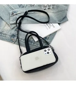 Mini black pebble leather handbag shown next to a smartphone for size reference