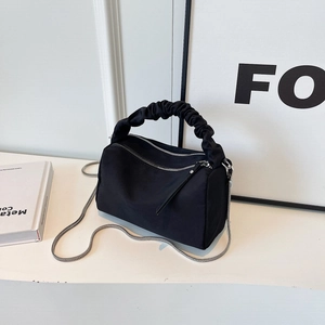 Minimalist black nylon dumpling bag with pleated cloud handle and silver chain strap