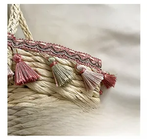 Close-up of straw beach bag with bohemian fringe tassels and wave pattern embroidery