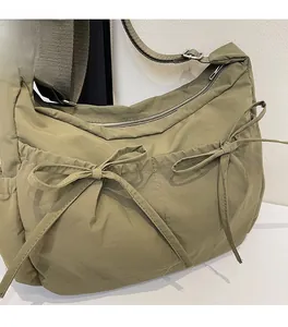 Detailed view of olive green nylon crescent bag with ruched design and ribbon bow