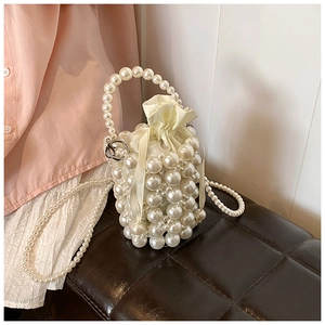 Détail du sac seau perlé à la main avec doublure en satin et poignée en perles tressées