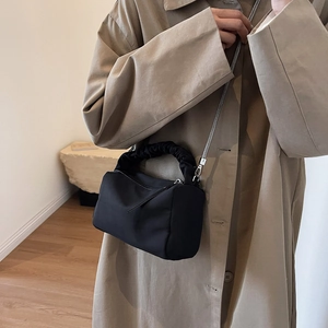 Minimalist black nylon dumpling bag with cloud pleated handle and silver chain strap