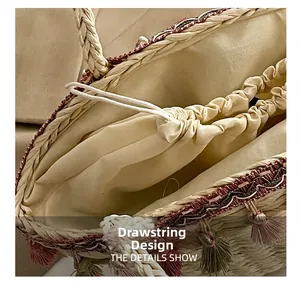 Detail view of woven straw bag featuring drawstring closure and decorative tassels
