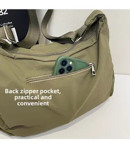 Detail view of the back zipper pocket of this olive green canvas crossbody bag for phone