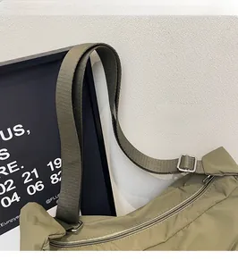 Detail view of olive green canvas bag showing adjustable nylon strap with metal buckle