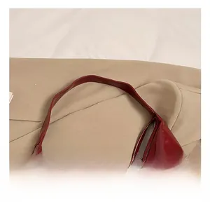 Detail view of burgundy glossy faux leather handbag with secure stitching and inner lining