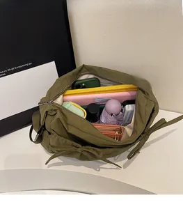 Interior view showing the large storage capacity of the green nylon shoulder bag