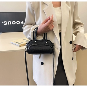 Chic black litchi pattern mini handbag styled with a cream blazer and long skirt