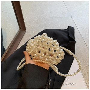 Close-up of handmade woven pearl bead handbag with elegant chain strap detail