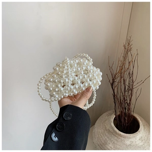 Detail view of a handmade white pearl beaded mini cloud bag with a long crossbody chain