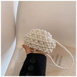 Detail of a handmade white pearl beaded mini handbag with an elegant pearl strap